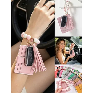 Detail view of pink silicone beaded wristlet with leather cardholder and tassel