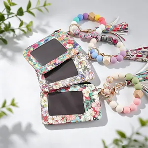 Détail de porte-cartes à imprimé fleuri avec porte-clés bracelet en perles de silicone.