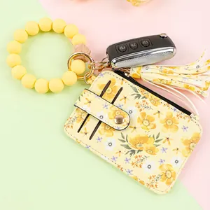 Close-up of floral card holder with yellow silicone bead wristlet keychain and tassel