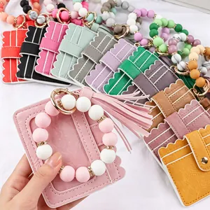 Detail view of pink silicone beaded wristlet with leather card holder and tassel.