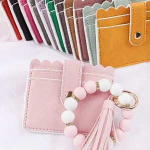 Close-up of pink leather card holder with beaded wristlet keychain and tassel