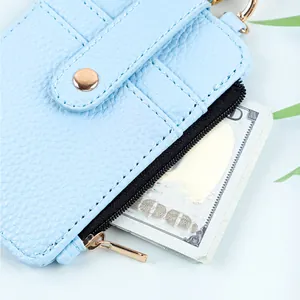 Detalle del tarjetero de cuero PU azul claro con bolsillo de cremallera y billetes.