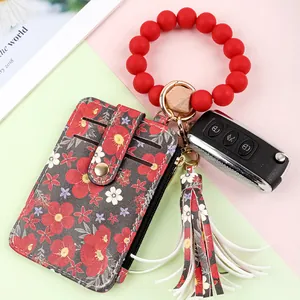 Close-up of floral print card holder with red silicone bead wristlet keychain