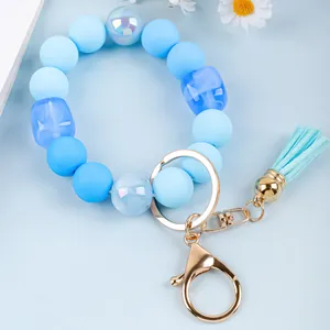Detailed shot of a sky blue silicone beaded wristlet keychain with a gold clasp