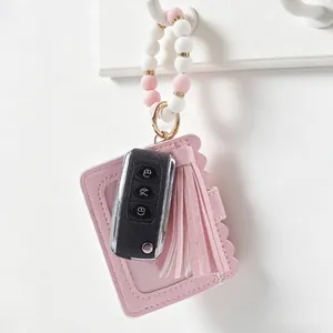 Detail of pink silicone beaded wristlet keychain with leather card holder and tassel
