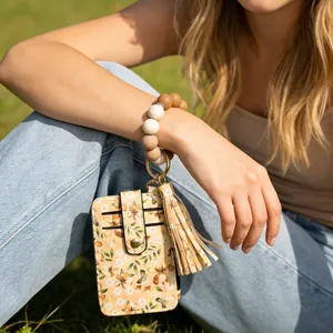 Detailansicht eines Kartenhalters mit Blumenmuster und Silikonperlen-Armband am Handgelenk