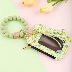 Close-up of floral print leather card holder with green silicone bead wristlet strap