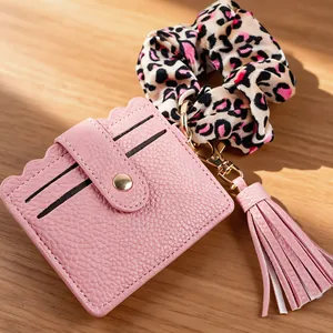 Detailaufnahme eines hochwertigen rosa PU-Leder-Kartenhalters mit Leoparden-Scrunchie