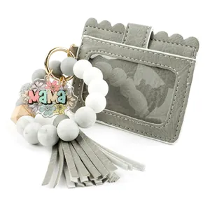 Détail du porte-clés en perles de silicone avec porte-carte en cuir PU et pompon