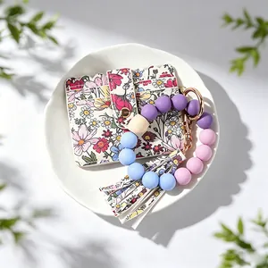Détail d'un porte-cartes à fleurs avec bracelet en perles de silicone et porte-clés coloré