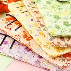 Macro detail of stacked multi-layer leather card holders featuring vibrant floral print patterns