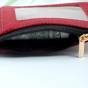 Primer plano del portatarjetas de cuero PU rojo con cremallera dorada y ventana.