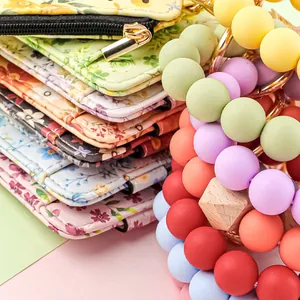Close-up of floral leather card holders with colorful silicone bead wristlet keychains