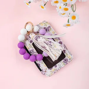 Detailaufnahme eines floralen Ausweishalters mit lila Silikonperlen-Schlüsselanhänger