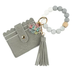 Détail du porte-cartes en cuir PU gris avec bracelet en perles silicone et breloque Mama