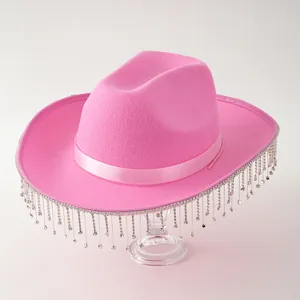 Detailed view of a bright pink felt cowboy hat featuring shimmering rhinestone tassels