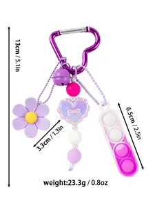 Detalle de llavero pop it de silicona con dije de corazón púrpura y cuentas antiestrés