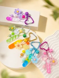 Detalle de llaveros de juguete antiestrés de silicona de colores con dijes de flores.