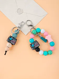 Vue détaillée des porte-clés d'infirmière en perles de silicone avec pompon et charms.