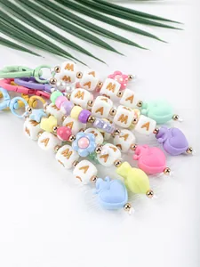 Detail view of colorful silicone beaded bag charms featuring MAMA letter beads and hearts