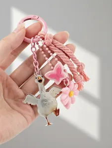 Detail view of pink keychain with cute white goose, butterfly and flower charms.