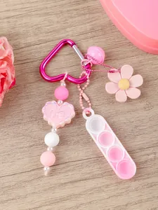 Detalle de llavero pop-it rosa con mosquetón de corazón y hermosas cuentas de colores