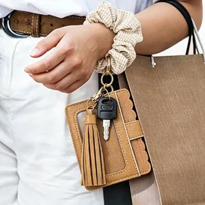 Detail view of a PU leather keychain card holder with scrunchie wristlet and tassel