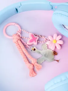 Close-up of pink keychain with flower, butterfly, and goose charms in ins style.