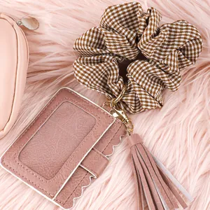Close-up of pink PU leather card holder keychain with plaid scrunchie and tassel
