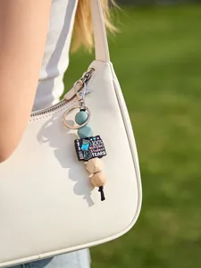 Détail d'un porte-clés pour étudiant en soins infirmiers avec perles en silicone et bois sur un sac