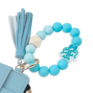 Close-up of blue leather card holder with matching silicone bead tassel keychain