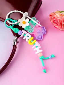 Close-up of colorful beaded bag charm with flower and bear fidget toy