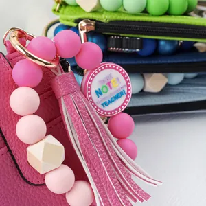Close-up detail of a pink leather coin purse featuring a colorful teacher appreciation charm