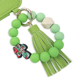 Detail view of green silicone bead wristlet with tassel and leather card holder wallet