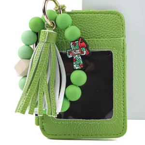 Detailed view of green leather card holder with beaded keychain and stylish tassel