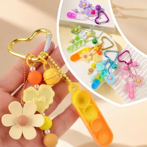 Set de llaveros pop fidget de silicona de colores con flores y mosquetones de corazón