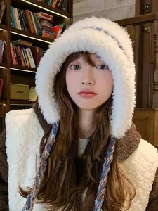 Cozy white faux fur earflap hat with colorful braided tassels for stylish winter warmth.