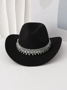 Vista detallada de un sombrero de vaquero negro con una banda de pedrería y flecos de cristal.
