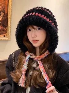 Close-up of a warm plush winter hat with colorful knitted straps worn by a model
