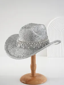 Detail of luxury silver cowboy hat with glitter texture, rhinestones and pearl dangles.