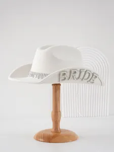 Dettaglio del cappello da cowboy da sposa bianco con lettere di perle e strass.