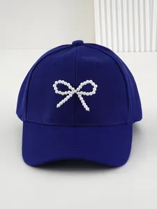 Vista dettagliata del berretto da baseball blu scuro con decorazione a fiocco di perle