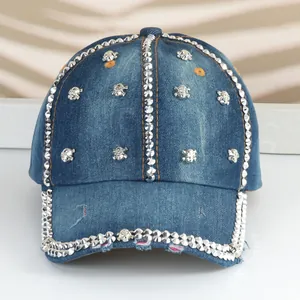 Dettaglio di un cappello da baseball in denim con teschi metallici e strass brillanti.