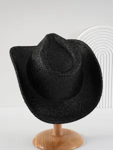 Detail view of sparkling black western cowboy hat with a curved brim on wooden stand.