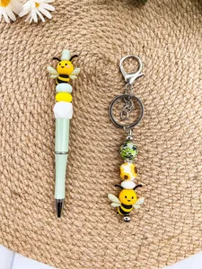 Cute bee silicone beaded pen and matching keychain set on a natural woven mat