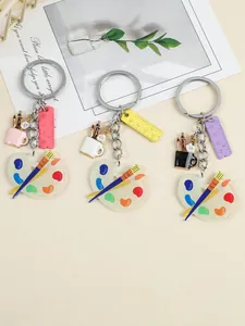 Vista detallada de creativos llaveros de paleta de arte con dijes de papelería coloridos