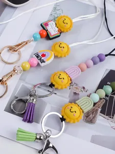 Detail of handmade silicone beaded keychains featuring cute sun and teacher rainbow charms
