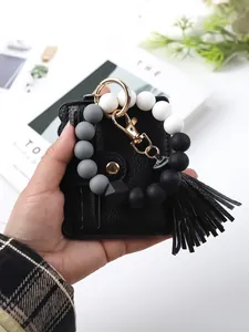 Hand-held detail of black PU card holder with silicone beaded wristlet keychain