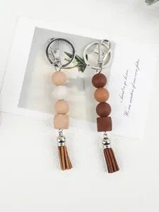 Detail of silicone beaded keychains with earthy tones and stylish tassels