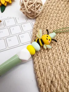 Close-up of cute cartoon bee silicone bead on a colorful DIY beaded pen or stylus